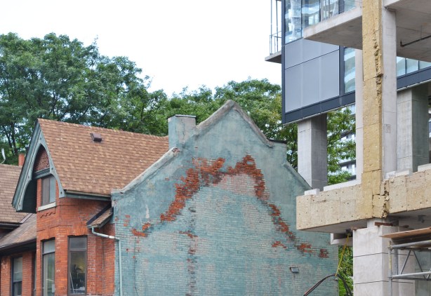 on the side of a brick house, two storey, Victorian, the remains of marks left behind on a house that was demolished, new development going up beside it 