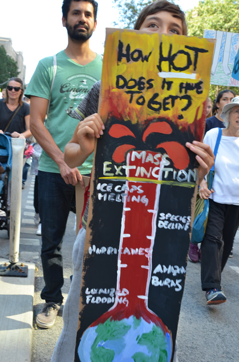 people at Toronto climate strike, walking along Wellesley street with signs, a giant thermometer with words how hot does it have to get, mass extinction is marked as the top temperature 
