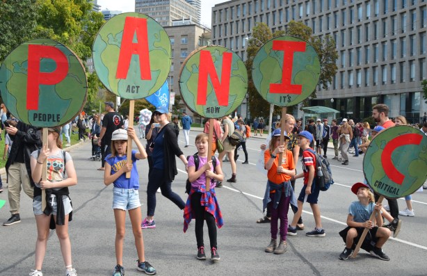 5 kids, each with a sign. Together they spell panic. each letter is in red on a green circle. The boy holding the C at the end is sitting on the ground