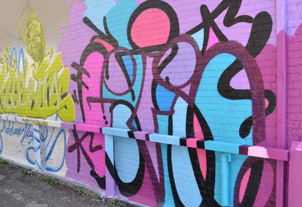 a mural of black lines making circles and other irregular shapes filled in with pinks, purples, and blues