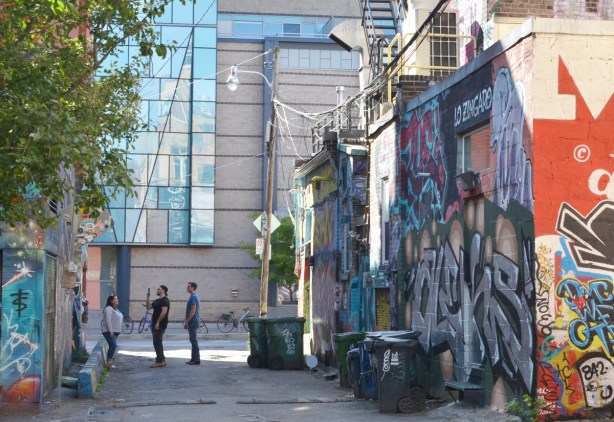 three people taking selfies at the Portland Street end of graffiti alley 