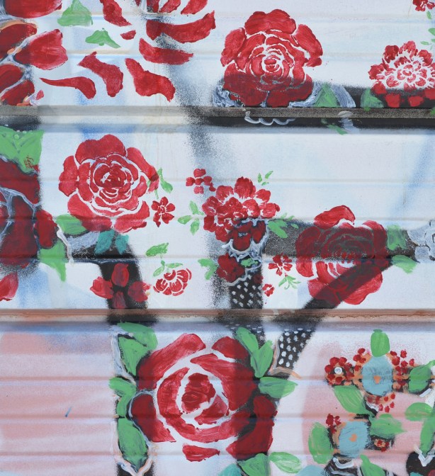 red rose stencil street art on a garage door 