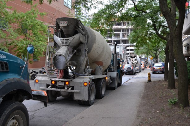 five or six cement trucks parked on a side street 