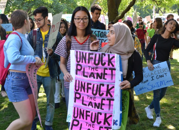 unfuck the planet, three times on pink paper, protest sign 