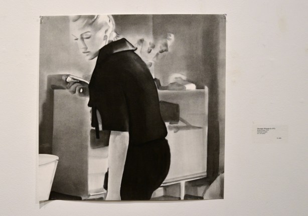 a charcoal drawing of a woman by Olexander Wlasenko on the wall of an art gallery