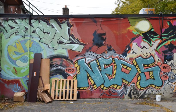 mural and graffiti on a wall in an alley