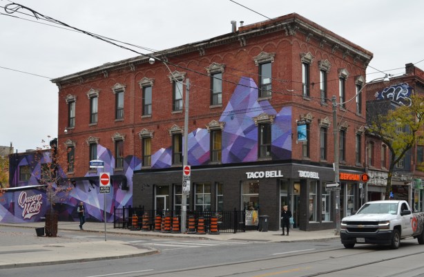 view from across the street, purple and black abstract street art mural on exterior of building at Queen West and Denison, old three storey brick building
