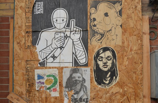 paper paste ups on plywood covering a window
