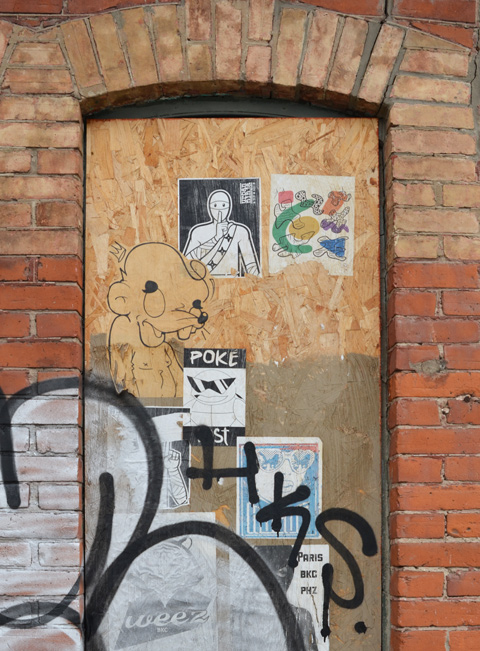 paper paste ups on plywood covering a door