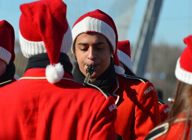 a young man from Malvern High School band is warming up before the Santa Claus parade 