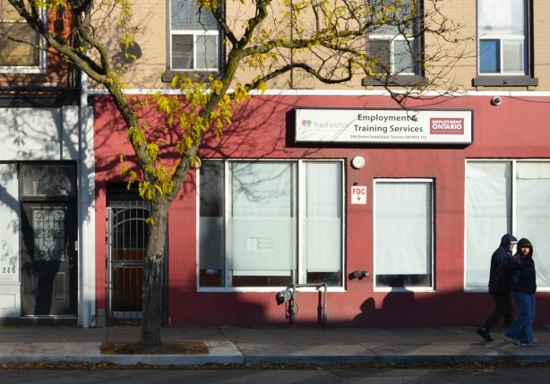 two men walk past on the sidewalk