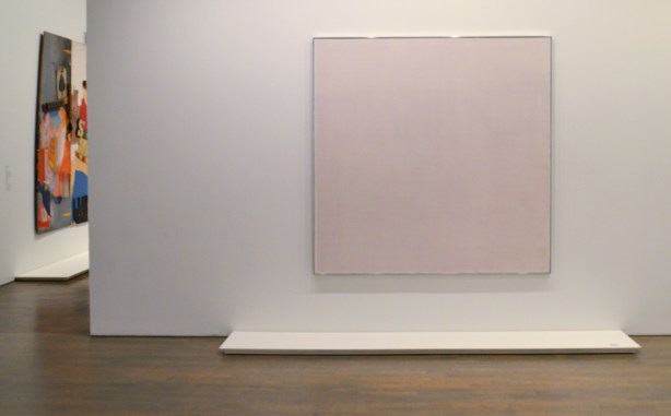 rose, a large canvas by Agnes Martin on a wall at the Art Gallery of Ontario, red pencil lines in a grid, it looks pink when viewed from a distance 