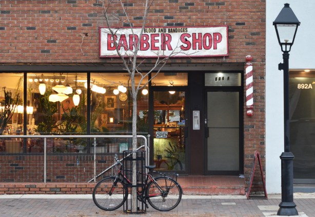 blood and bandages barber shop from the outside, lights in window, bike parked outside