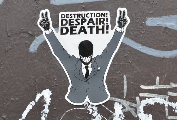 a sticker of a black faceless man in grey suit, black tie, and black gloves, with arms raised with two hands in peace symbol, words that say destruction, despair, death 