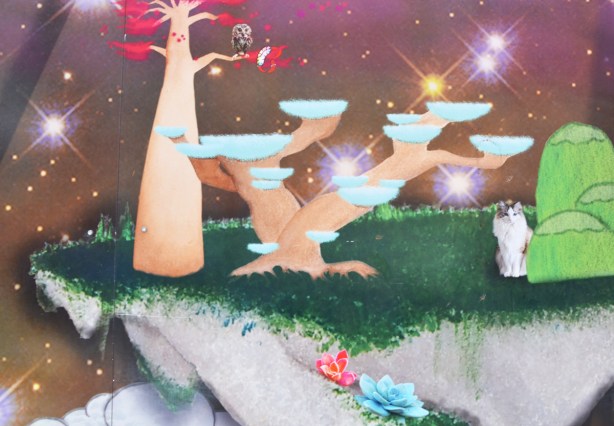 picture on construction hoardings on Bloor St near Bathurst, an owl in a tree, a cat sitting below the tree, trees are weird shapes