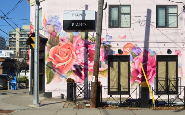 new Piano Piano restaurant on the corner of Mt. Pleasant and Manor Rd painted pink with large flowers, windows still papered over, painted by street artist bacon