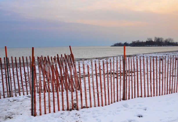 sunset behind Lake Ontario at Woodbine Beach, snow fence, some snow on the ground