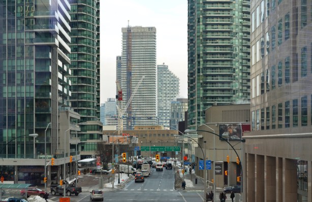 view east on Harbour Streeet from the walkway between Waterpark Place and Scotiabank Arena, construction of new high rises in the background, traffic, 