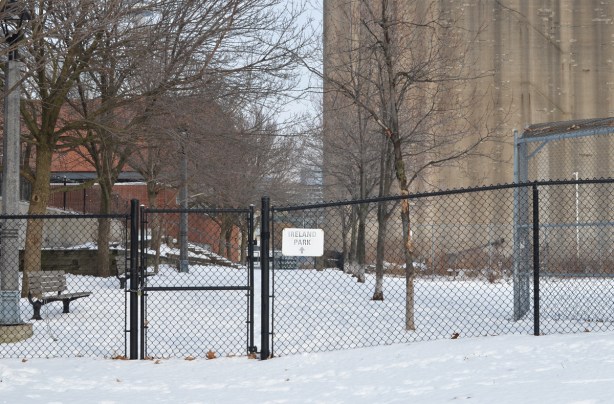 winter scene, base of Bathurst street by old Canada Malting Co silos, black gate to Ireland Park path is locked, snow, bench, 