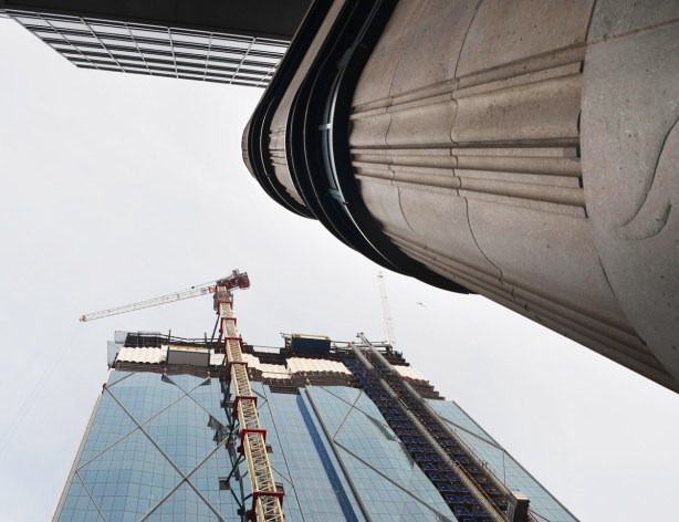 looking up towards the sky at the Bay Street entrance to Scotianbank arena, wall of old arena, top of new building being constructed across the street, 