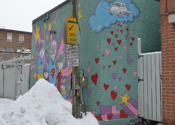 mural by Bonfanti and Tarantino of superhero kids and los of pink and red hearts, a yellow star and a car with wings flying in a blue cloud