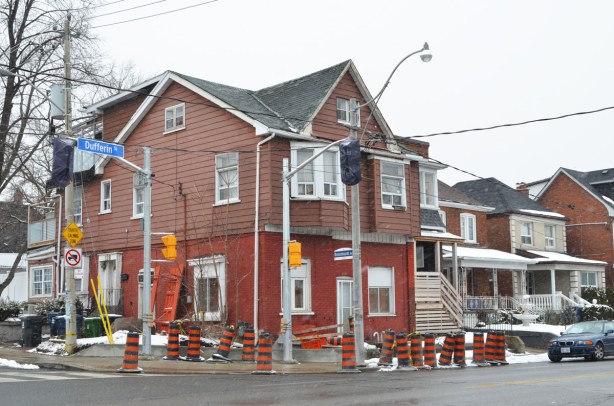 large house on the north west corner of Dufferin and Rosemount. Brick on the bottom, brown siding on the top, construction cones on the sidewalk around it