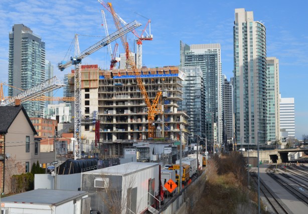 looking east along the north side of the railway tracks from Portland Street towards downtown, cranes and construction site, high rises 
