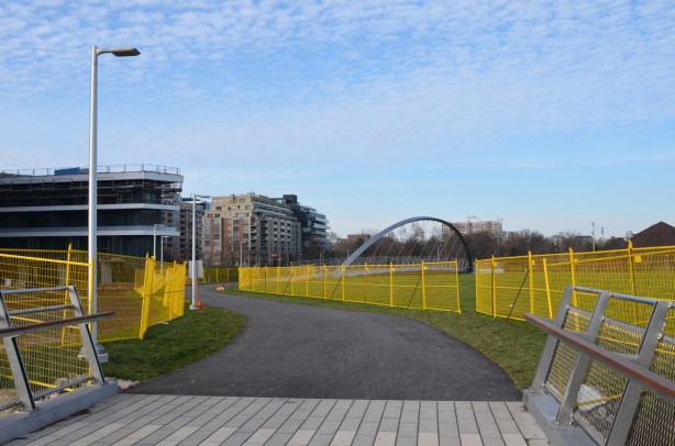 yellow construction fences line the pathway through the middle of Garrison Crossing as it is not quite finished construction