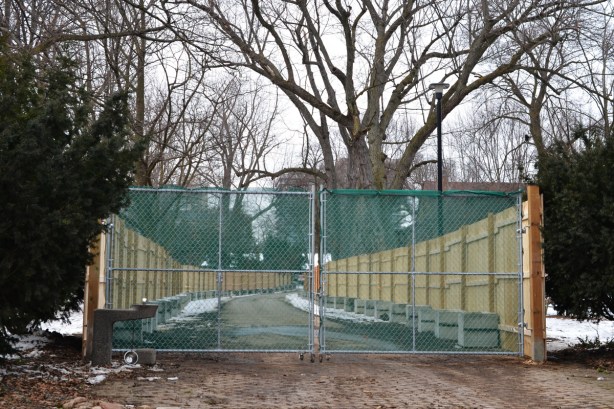 fence and gate blocking a walkway through a park, construction zone now 