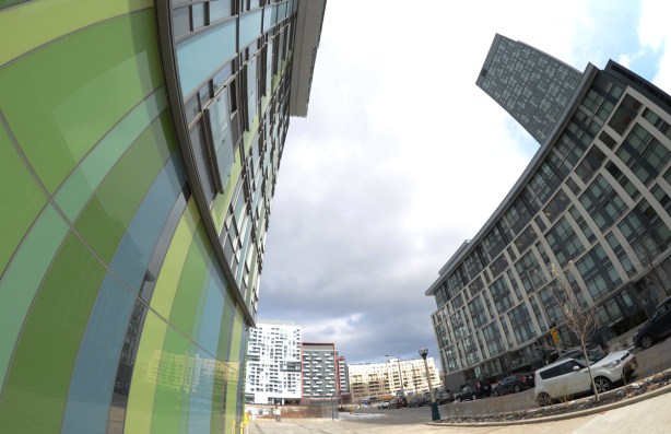 fish eye lens view of side of green library condo building and the other across the street, Queens Wharf Rd 
