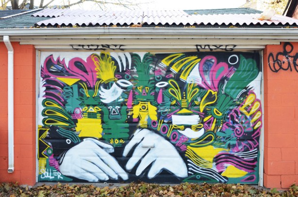 street art on a garage door including a large pair of white hands