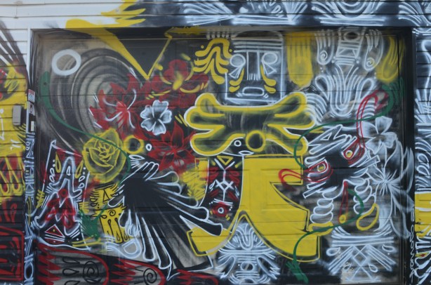 a garage door completely covered in paint, street art in red, black and yellow