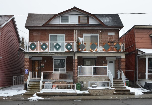 a 2 storey semi divided house on Dufferin, upper level has a balcony with with a green and white railing, winter, snow on the ground