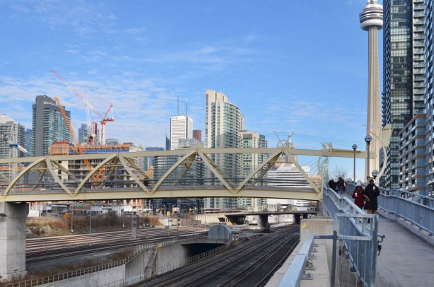 looking eastward to the puente de luz bridge and the city skyline beyond, railway tracks, cranes, new buildings, 