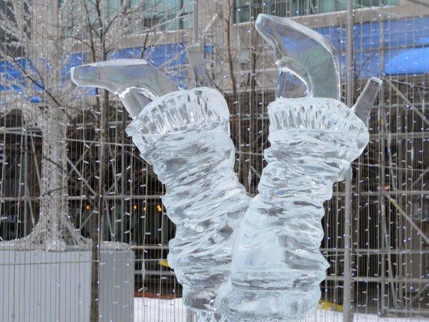 ice sculpture of a pair of legs, upside down, with high platform shoes and leg warmers