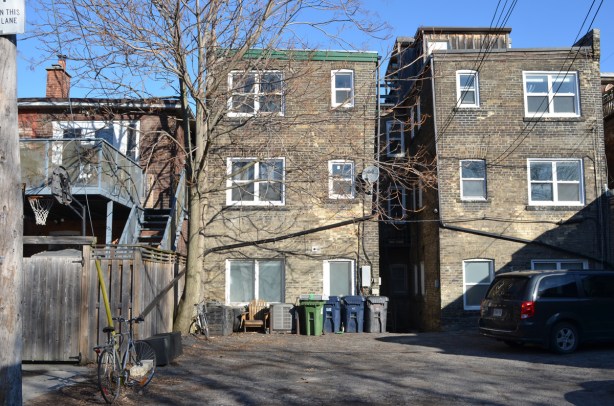 3 storey brick building, from the back in the alley, behind Queen Street East 
