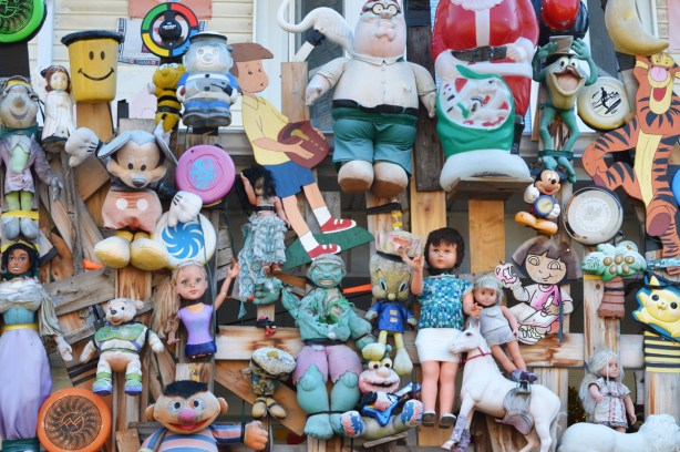 some of the dolls and toys attached to the front wall of a house 