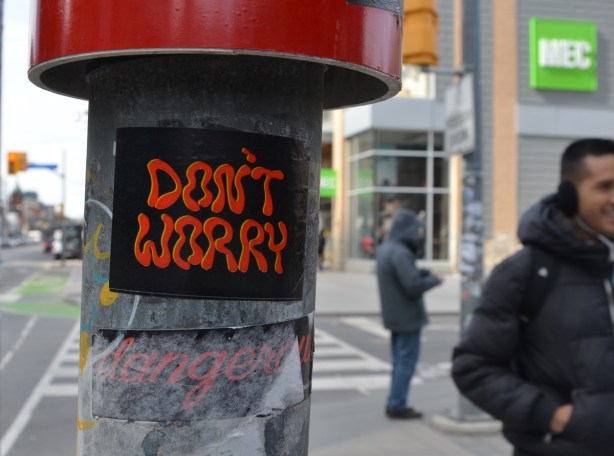 don't worry sticker on a pole 