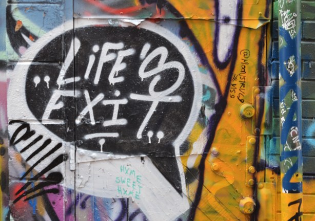 graffiti on a wall including the words Life's exit