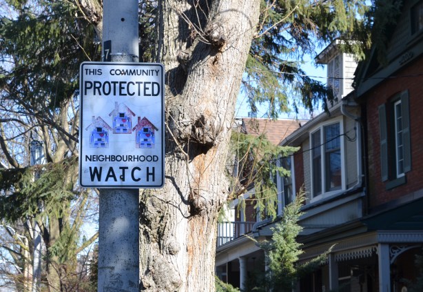 neighbourhood watch sign with 3 lovebot stickers on it 