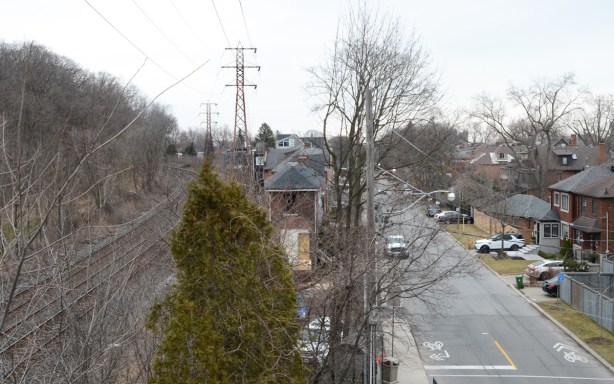 view from pedestrian railway bridge, Summerhill Ave., with houses, tracks, street, and trees, early spring