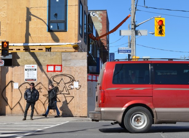 two people waiting on the corner for a green light