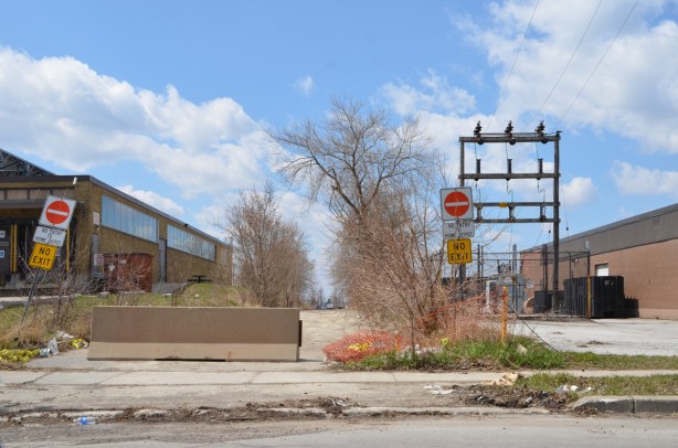 hydro poles and concrete barrier blocking access to street behind 