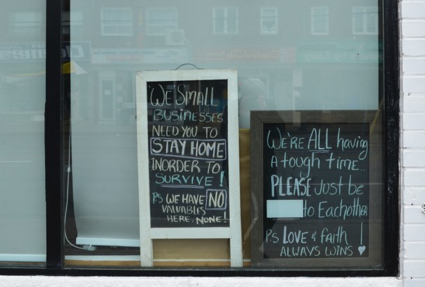 two chalkboard signs in the window of a store 