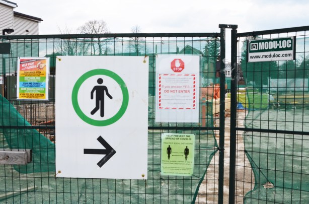 fence in front of construction site at Chester subway station, sign with arrow pointing way for pedestrians