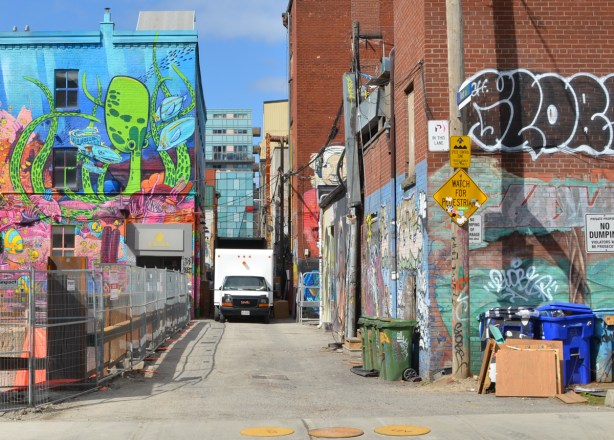 a large white truck is parked in the narrow Graffiti Alley totally blocking it 