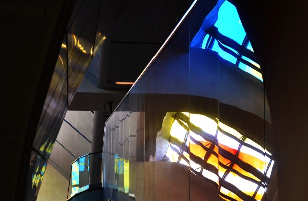 light coming through coloured glass and bouncing colours off walls and reflective surfaces inside subway station