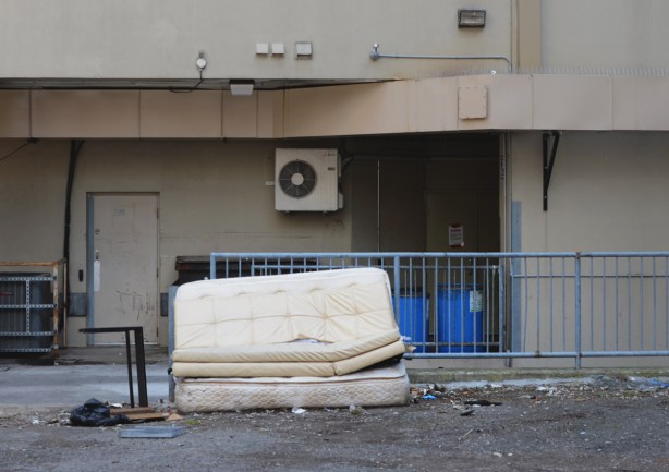two mattresses discard in a lane beside a blue railing