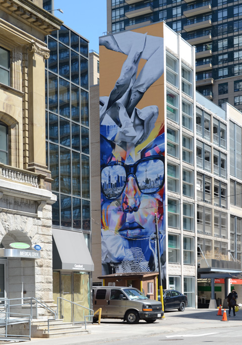 tall mural onthe side of an apartment building, about 10 storeys high 