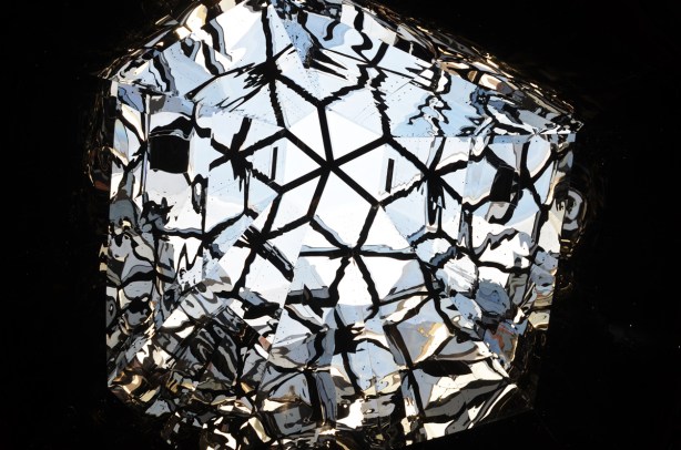 many sided opening in a ceiling, sides covered with reflective material so the light bounces around, many reflections, 